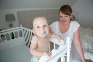 Mutter mit Baby am Gitterbett Mutter mit Baby am Gitterbett